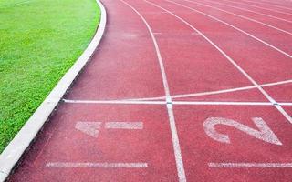 números iniciando ponto em vermelho corrida rastrear, correr rastrear e verde grama, direto atletismo corrida rastrear às esporte estádio foto