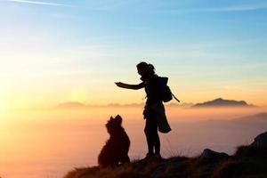 menina brinca com seu cachorro nas montanhas foto