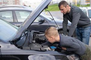 Papai mostra dele pequeno feliz filho quão a carro trabalho foto