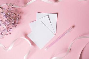 adesivos para escrevendo com uma caneta em uma Rosa fundo Próximo para uma branco fita e branco flores foto