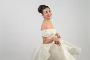 jovem noiva linda asiática sorri com feliz no fundo branco foto