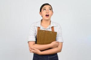 retrato de jovem asiática em pose de uniforme de garçonete com prancheta foto