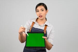 retrato de jovem asiática em pose de uniforme de garçonete com tablet digital foto