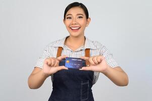 retrato de jovem asiática em uniforme de garçonete pose com cartão de crédito foto