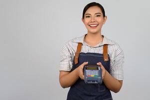 retrato de jovem asiática em uniforme de garçonete pose com cartão de crédito foto