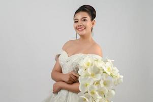 jovem noiva linda asiática sorri com feliz no fundo branco foto