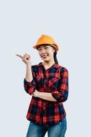 jovem ásia engenheiro fêmea em pé com ponto dedo postura foto