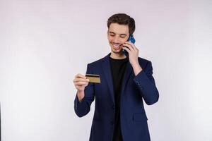 retrato do feliz bonito homem de negocios falando de Móvel telefone e segurando crédito cartão isolado sobre branco fundo foto