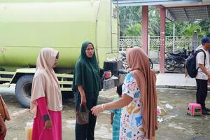 kuaro leste Kalimantan, Indonésia marcha 13, 2023 mulheres fila para massa cozinhando óleo foto