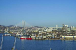 paisagem urbana com corpo d'água e porto com céu azul claro em Vladivostok, Rússia foto