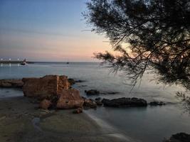 praia mediterrânea sem pessoas ao pôr do sol em calpe, alicante foto