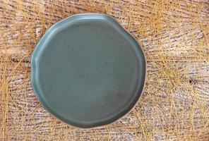 vista superior de um prato de cerâmica vazio sobre um fundo de mesa de madeira foto