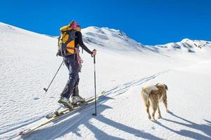 menina faz esqui alpino com cachorro foto