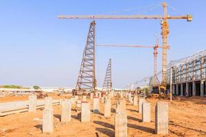 guindastes de construção industrial e edifício em um fundo de céu azul lindo foto