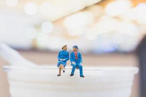 casal em miniatura sentado em uma xícara, conceito de dia dos namorados foto