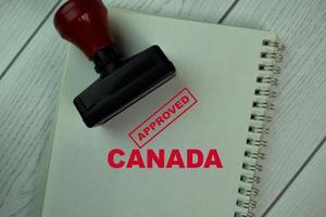 Carimbo de borracha de alça vermelha e texto aprovado do Canadá isolado na mesa foto