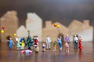 Papai Noel em miniatura e uma família feliz, conceito de feliz natal e feliz ano novo foto