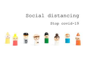 pare de covid-19 texto de distanciamento social com pessoas em miniatura em um fundo branco, conceito de distanciamento social foto