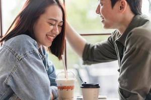 jovem casal asiático namoro em cafeteria foto