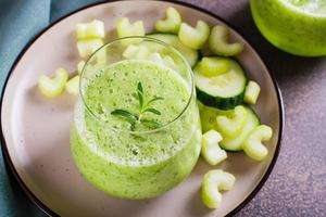 pepino e salsão batido para vegetariano antioxidante dieta dentro vidro em mesa foto