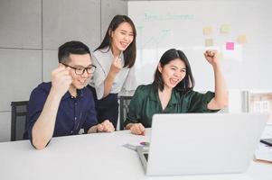 jovens empresários asiáticos felizes comemorando o sucesso foto