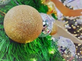 bola de natal pendurada em galhos de pinheiro com um fundo festivo foto