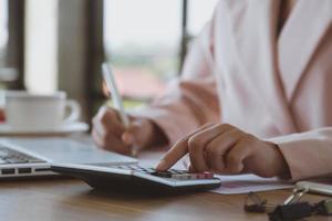 jovem empresária trabalhando em um laptop em sua estação de trabalho foto