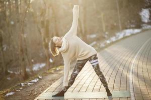 uma jovem atlética realiza exercícios de ioga e meditação ao ar livre foto