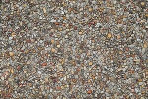 mosaico de pequenas pedras de cascalho pedaços de rocha textura de parede de pedra foto