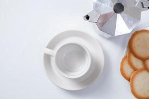 caneca de café vazia com biscoitos no fundo branco foto