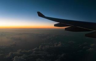 asa avião e a Visão a partir de a altura do a janela avião dentro crepúsculo céu foto