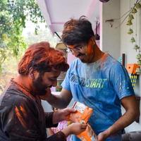 Délhi, Índia - fevereiro 26 2023 - indiano família pessoas jogando cores em holi festival, segurando diferente cores, holi festival celebrações dentro Délhi, Índia foto