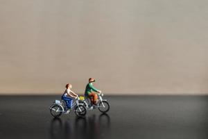 viajantes em miniatura andando de bicicleta, conceito de estilo de vida saudável foto