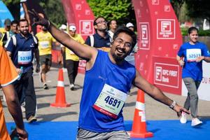 nova delhi, índia - 16 de outubro de 2022 - vedanta delhi meia maratona após covid em que os participantes da maratona prestes a cruzar a linha de chegada, meia maratona de delhi 2022 foto