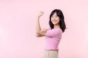 retrato jovem ásia mulher orgulhoso e confiante mostrando Forte músculo força braços flexionado posando, sente sobre dela sucesso conquista. mulheres fortalecimento, igualdade, saudável força e coragem conceito foto