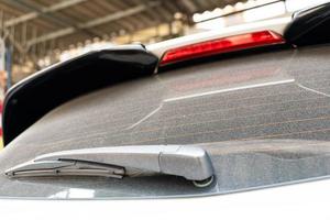 retrovisor do carro sujo hatchback da janela traseira em um vidro empoeirado. janela traseira suja e empoeirada de um carro branco ou cinza. não se esqueça de lavar seus carros manualmente ou em lavagens de carros foto