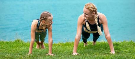 mulher e menina fazendo flexão exercício foto