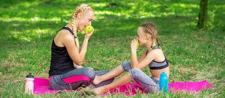 mãe com filha come maçãs foto