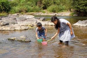 ásia meninas e Rapazes estão tendo Diversão explorando a aquático ecossistema. a conceito do Aprendendo lado de fora a sala de aula, casa escola, natural Aprendendo recursos. suave e seletivo foco. foto