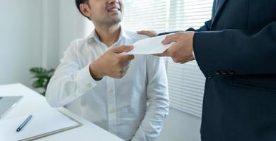 os empresários recebem salário ou bônus da administração ou do chefe. empresa dar recompensas para incentivar o trabalho. empresário sorridente desfrutando de uma recompensa na mesa do escritório. foto