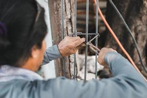 construção trabalhadores usando fio cortador alicate e aço fio para obrigatório fio dentro reforço reforçado concreto estruturas ,construção e indústria conceito foto