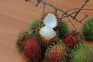 rambutan fruta que é avermelhado verde dentro cor tendo doce gosto isolado em mesa. Comida conceito foto. foto