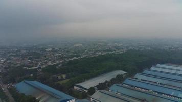 aéreo Visão do fábricas e verde árvores e assentamentos com nublado clima. foto