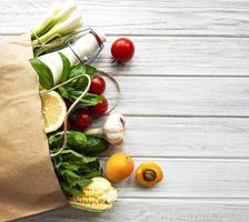 comida saudável em saco de papel, vegetais e frutas foto