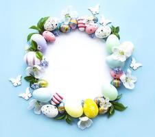 ovos de páscoa, flores coloridas em fundo azul pastel foto