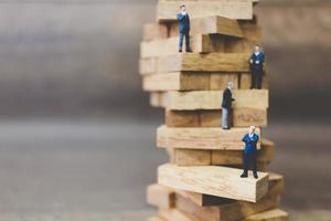 empresários em miniatura em cima de blocos de madeira foto