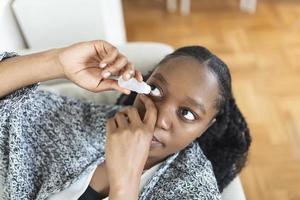 mulher usando olho derrubar, mulher caindo olho lubrificante para tratar seco olho ou alergia, doente mulher tratando globo ocular irritação ou inflamação mulher sofrimento a partir de irritado olho, ótico sintomas foto