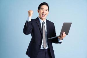 retrato de empresário asiático vestindo terno sobre fundo azul foto