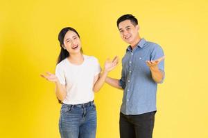 imagem de casal asiático posando em fundo amarelo foto