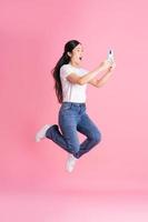 imagem de corpo inteiro de menina asiática posando em fundo rosa foto